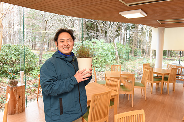 レストランの料理にも使うハーブのタイムを持つ綿引さん